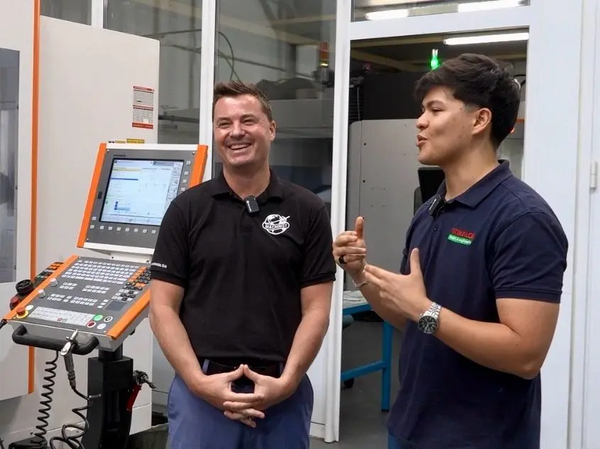 Tony Gunn y un técnico de Mikalor Tools & Engineering revisando un centro de mecanizado durante la visita a las instalaciones